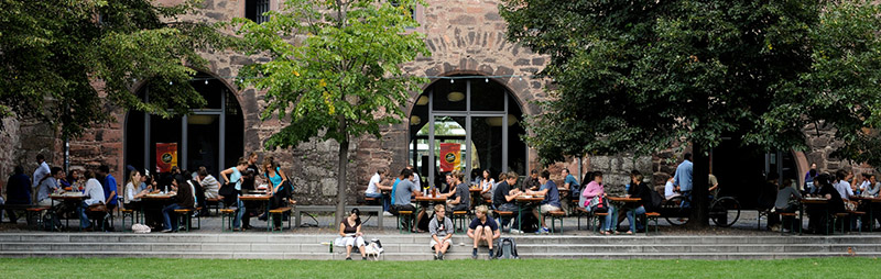 Zeughaus-Mensa Heidelberg – Gemütlicher Innenhof mit Sitzplätzen und einer Ausgabe für warme Mahlzeiten.