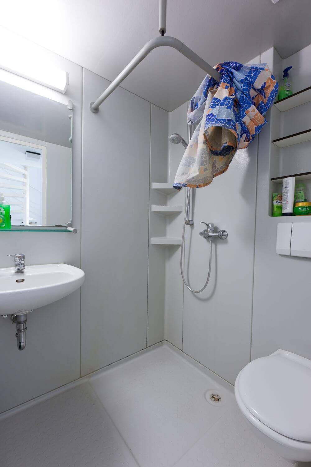 Kompaktes Badezimmer mit integrierter Dusche, Waschbecken und WC in funktionalem Design