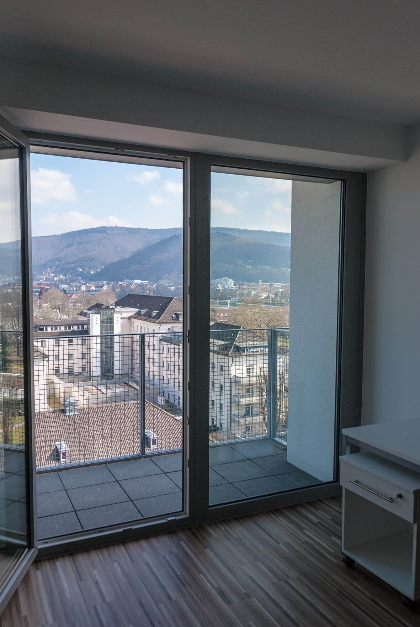 View from the balcony of a student residence with a view of the city and surrounding hills
