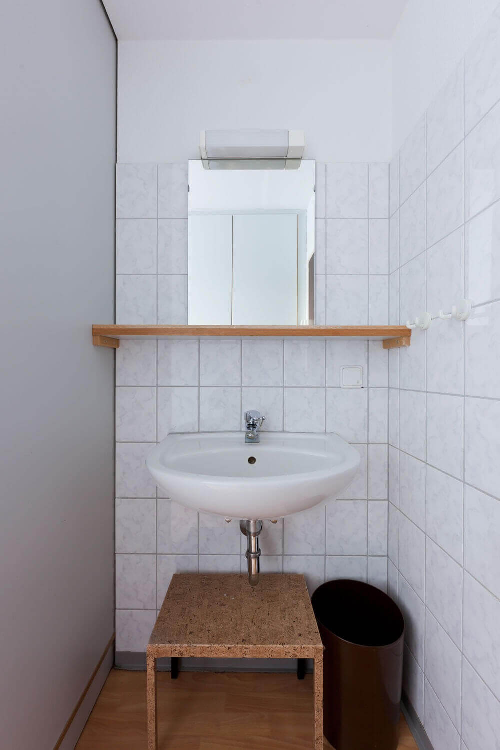 Waschbereich mit Spiegel, Waschbecken und Ablagefläche in einem Gemeinschaftsbad